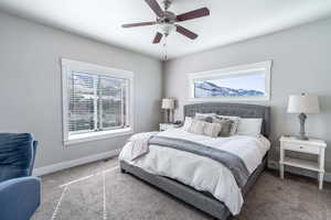 Bedroom with a ceiling fan, baseboards, and carpet