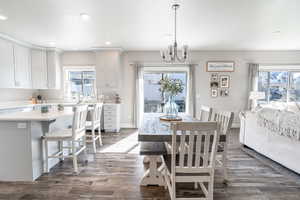 Dining area featuring dark wood finished floors, recessed lighting, a chandelier, and plenty of natural light