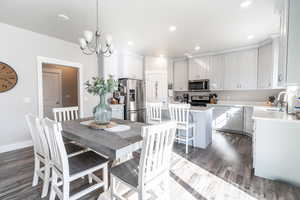 Dining area featuring recessed lighting, baseboards, dark wood-style floors, and a notable chandelier