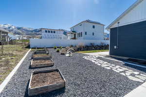 View of yard with a garden, fence, and a mountain view