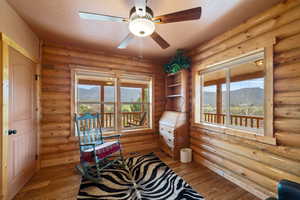 Living area featuring a wealth of natural light, a ceiling fan, light wood-style floors, and a mountain view