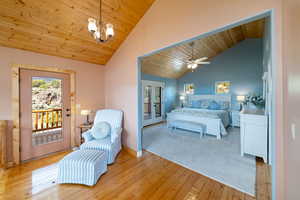 Bedroom with wooden ceiling, access to outside, multiple windows, and hardwood / wood-style floors