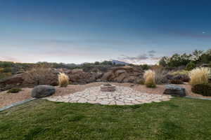 Yard at dusk featuring a fire pit and a patio area