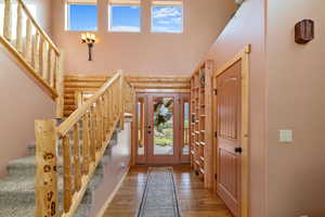 Entryway featuring a wealth of natural light, log walls, and stairs
