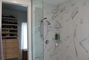 PrimaryBathroom featuring a marble finish shower