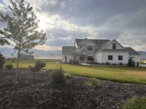 View of front of home with board and batten siding, a front lawn, and a mountain view