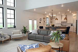 Living area featuring light wood-type flooring, recessed lighting, and a notable chandelier