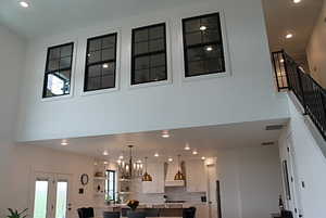Interior space featuring stairway, an inviting chandelier, a towering ceiling, and recessed lighting