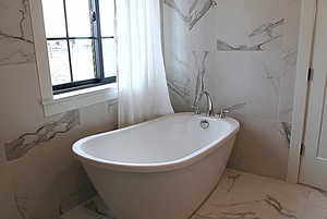 Primary Full bathroom with tile walls, a soaking tub, and marble finish floor