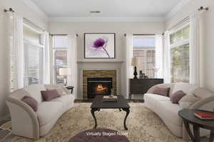 Interior space with a fireplace, visible vents, and crown molding