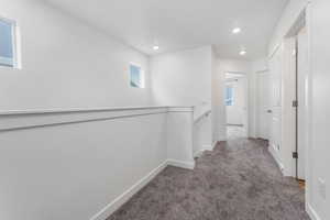 Corridor with baseboards, carpet floors, an upstairs landing, and recessed lighting