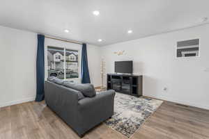 Living room with baseboards, wood finished floors, visible vents, and recessed lighting