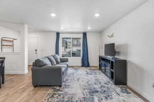 Living area featuring baseboards, wood finished floors, and recessed lighting