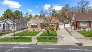View of front facade featuring a garage, brick siding, a front yard, and concrete driveway