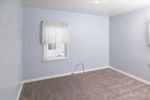 Spare room with baseboards and carpet
