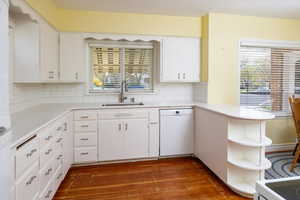 Kitchen with open shelves, dishwasher, a sink, and a healthy amount of sunlight