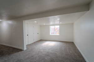 Below grade area with carpet floors, baseboards, a textured ceiling, and recessed lighting