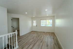Spare room featuring recessed lighting, light wood finished floors, and baseboards