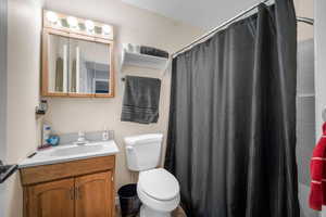 Bathroom featuring vanity, a shower with shower curtain, and toilet