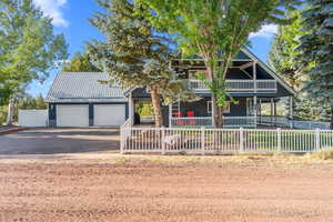 Rustic home with a porch, fence private yard, aphalt driveway, and a garage