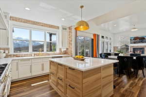 Kitchen with open floor plan, a mountain view, gas range, and dark wood-style floors