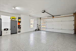 Garage with a garage door opener and baseboards