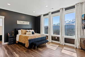 Bedroom featuring dark wood-style flooring, baseboards, recessed lighting, and multiple windows