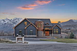 View of front of property featuring a chimney, stone siding, board and batten siding, and french doors