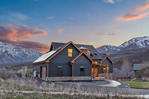 Chalet / cabin featuring board and batten siding, an attached garage, stone siding, and a mountain view