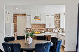 Kitchen featuring white cabinets, light countertops, dishwasher, and high end fridge