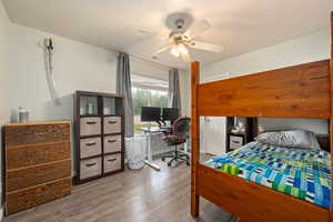 Bedroom with ceiling fan, baseboards, and wood finished floors