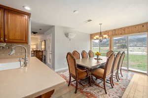 Dining area featuring a chandelier, a textured ceiling, light wood-type flooring, and visible vents