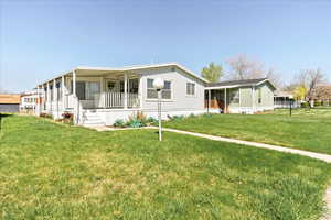 Manufactured / mobile home featuring a porch and a front lawn