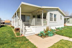 View of front of home featuring a front yard and covered porch