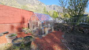 View of greenhouse featuring fence and a mountain view