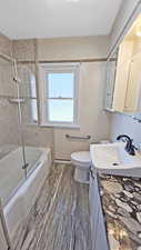 Full bathroom with wood finished floors, toilet, vanity, and  shower combination