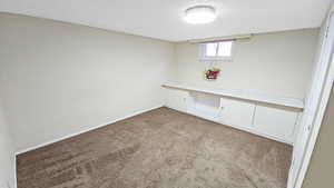 Bedroom with carpet, a textured ceiling, and baseboards