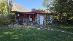 Shed with covered sitting area, a mountain view, an outbuilding, a yard, and metal roof