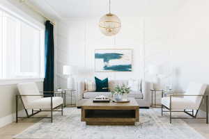 Sitting room with wood finished floors and an inviting chandelier