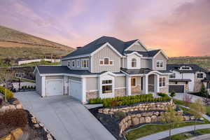 Craftsman-style home featuring concrete driveway, stone siding, board and batten siding, an attached garage, and a porch