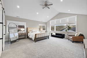 Bedroom with light carpet, visible vents, recessed lighting, and a barn door