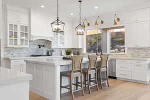 Kitchen with decorative backsplash and white cabinetry