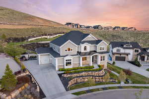 View of front of property with driveway, a porch, stone siding, and board and batten siding