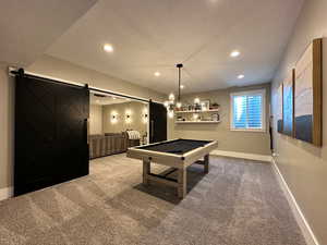 Playroom with a barn door, a textured ceiling, and carpet