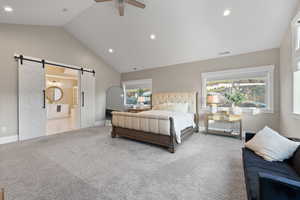 Carpeted bedroom featuring a barn door, vaulted ceiling, baseboards, visible vents, and recessed lighting