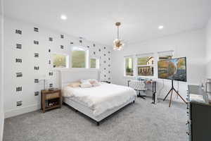 Bedroom with light carpet, a notable chandelier, multiple windows, and recessed lighting