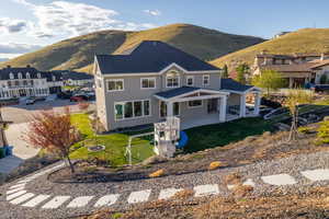 Back of property with stucco siding, a mountain view, a patio, and an outdoor fire pit