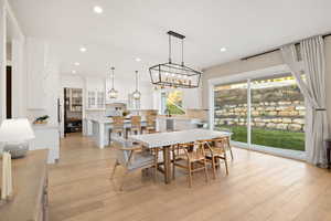 Dining area featuring a notable chandelier, recessed lighting, and light wood-style floors