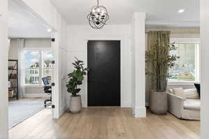 Foyer with plenty of natural light, a notable chandelier, hardwood / wood-style floors, and recessed lighting