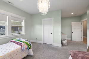 Bedroom with baseboards, carpet floors, and visible vents